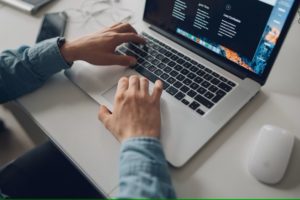 Man's hands typing on laptop